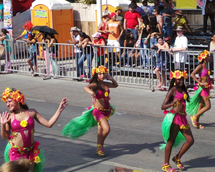 two women in dress in a parade dancing with people in the background