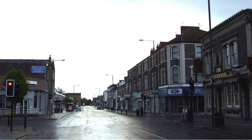 a quiet street is lit with traffic lights