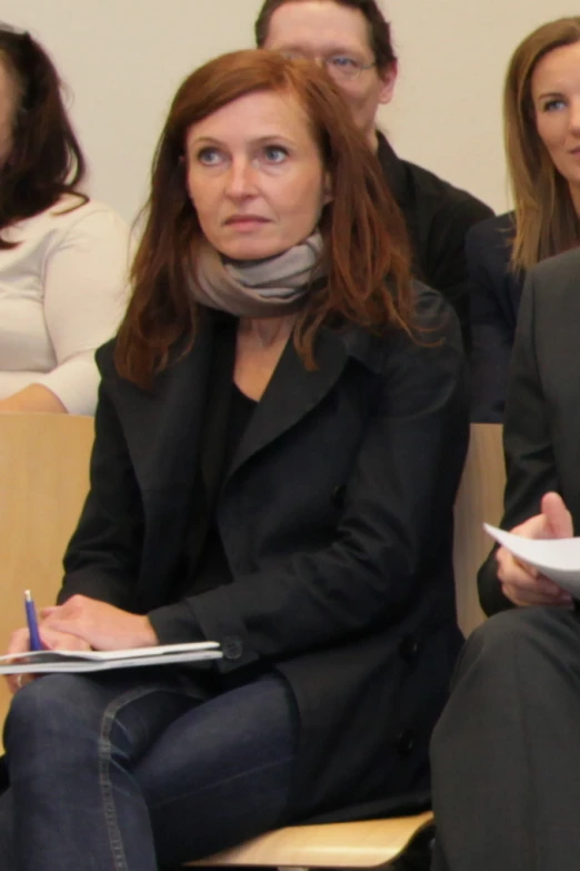 a woman with red hair sitting down in a chair