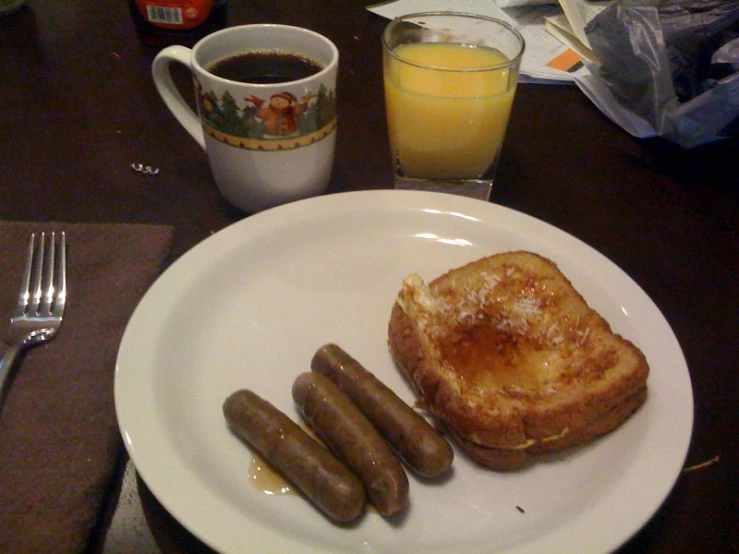 a plate with some toast, toasted vegetables and two sausages