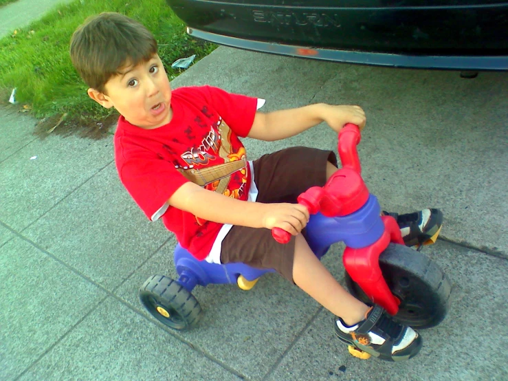 a little boy riding a scooter with a toy