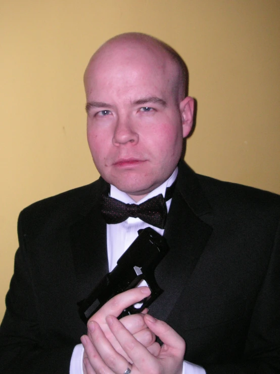 a bald man is wearing a jacket and tie