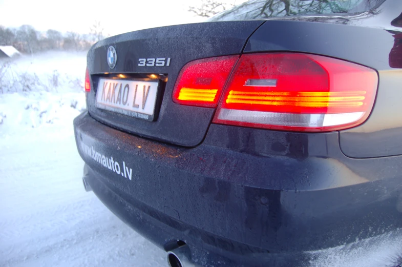 a car parked in the snow with its tail light on