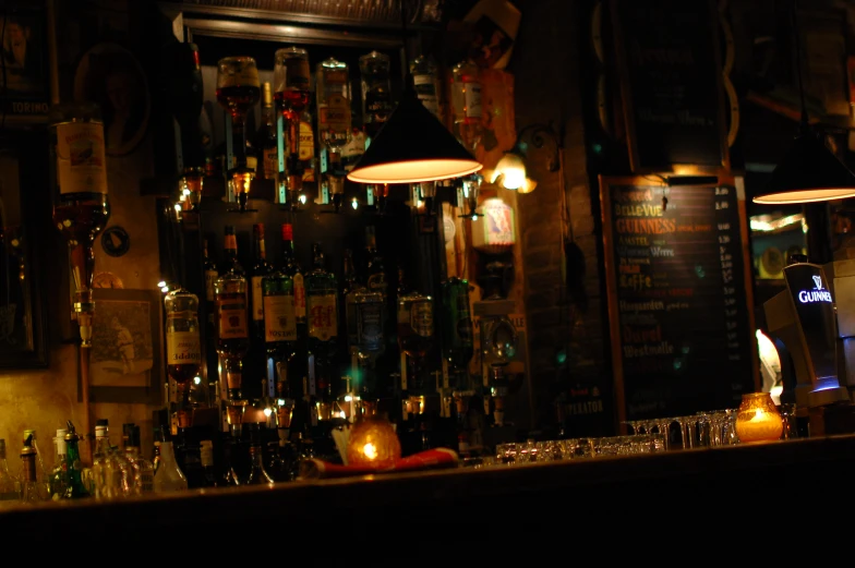 a bar with lighted lights and dark, cluttered bottles