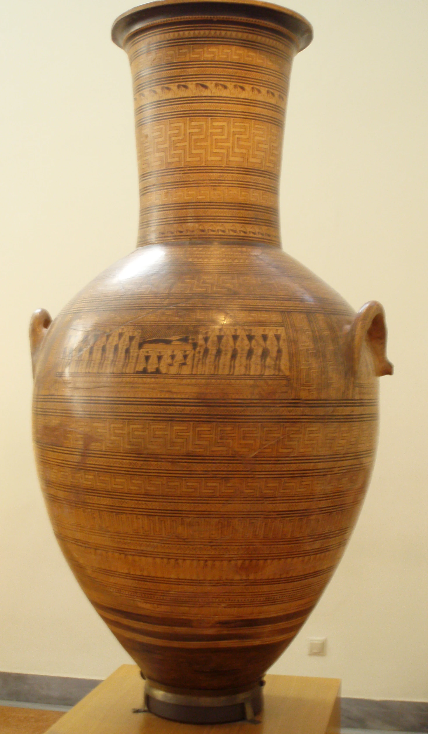 an old vase sits on a table on display