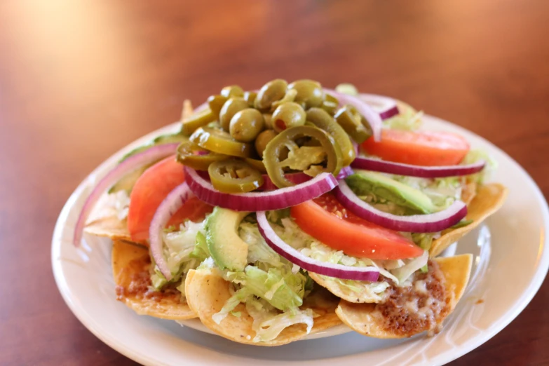 an entree on a white plate with lettuce and sliced olives