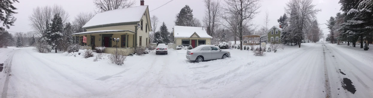 cars are on the snowy road next to trees