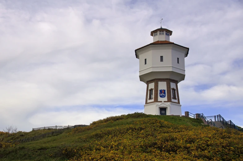 the tall white tower stands atop the hill