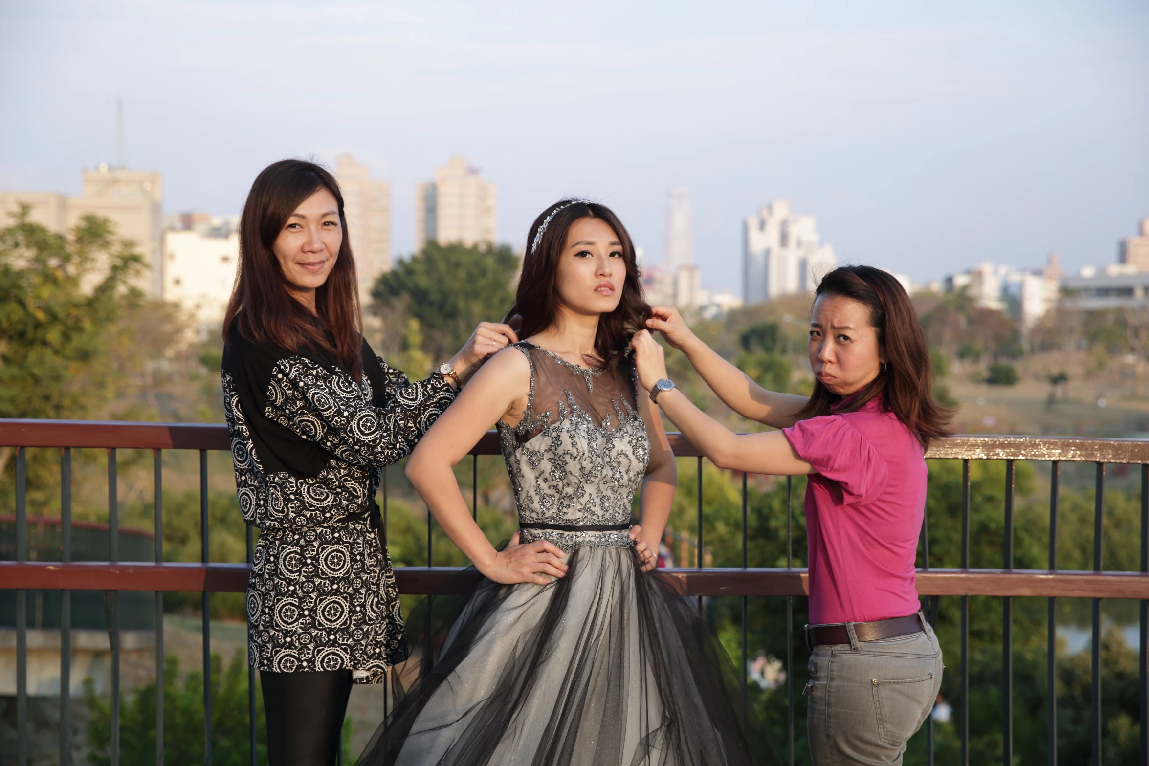 a group of young woman standing next to each other on top of a bridge