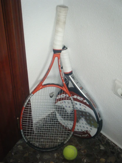 a close up of a racket with a tennis ball near it