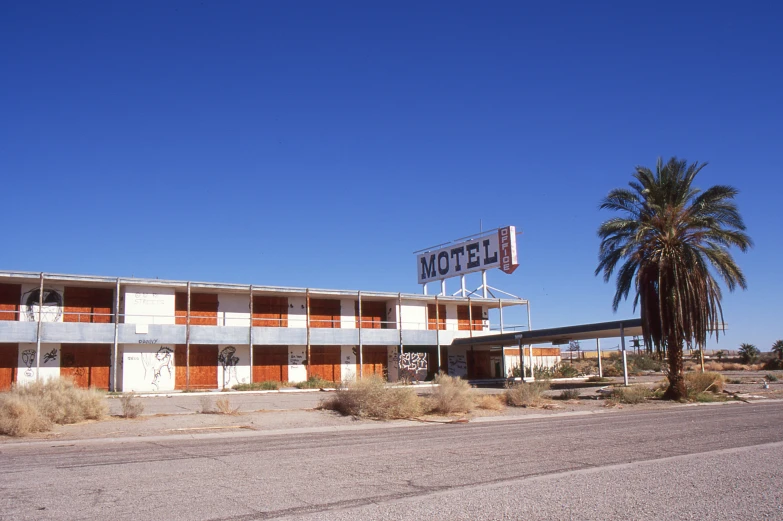 an empty motel is seen on a deserted road