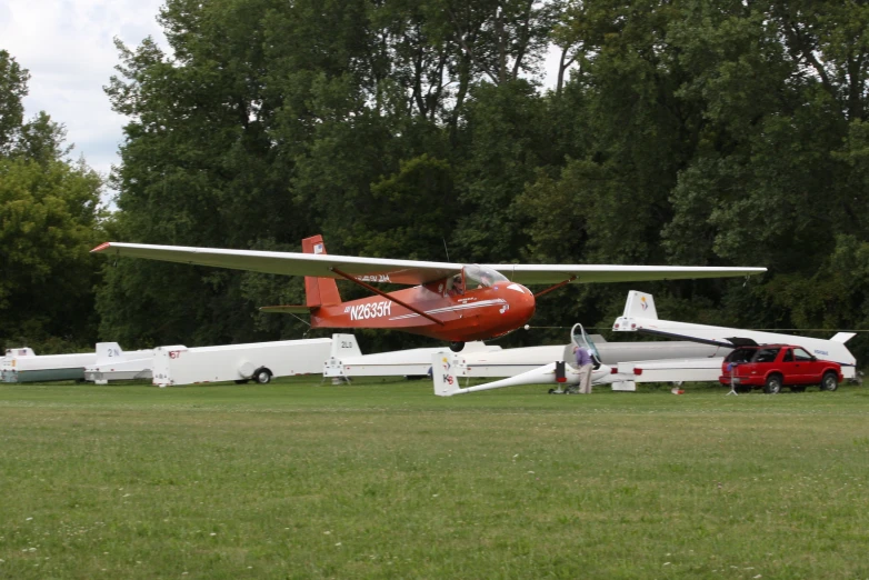 a red and white plane sitting on top of a green field