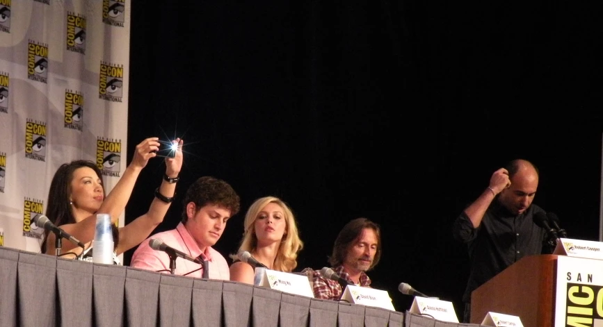 the three actors at the convention are taking pictures