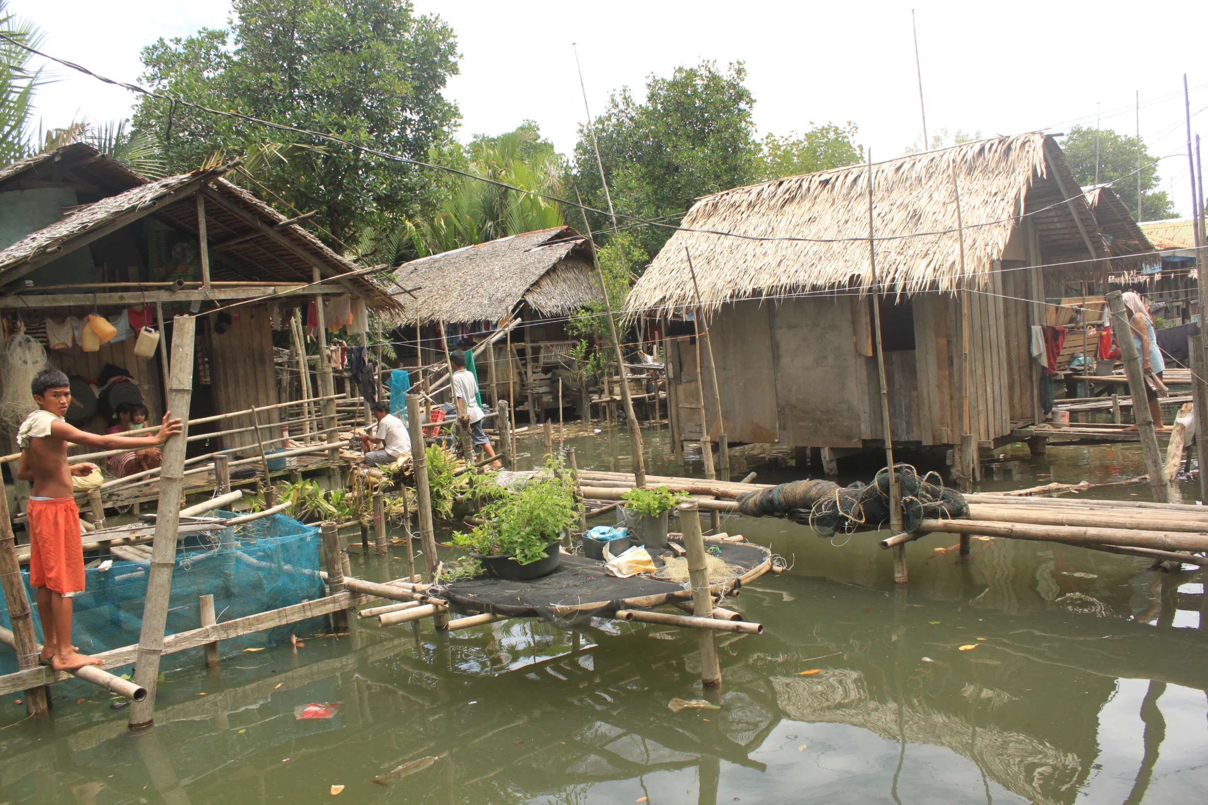 people at home in their floating village with some overgrowth