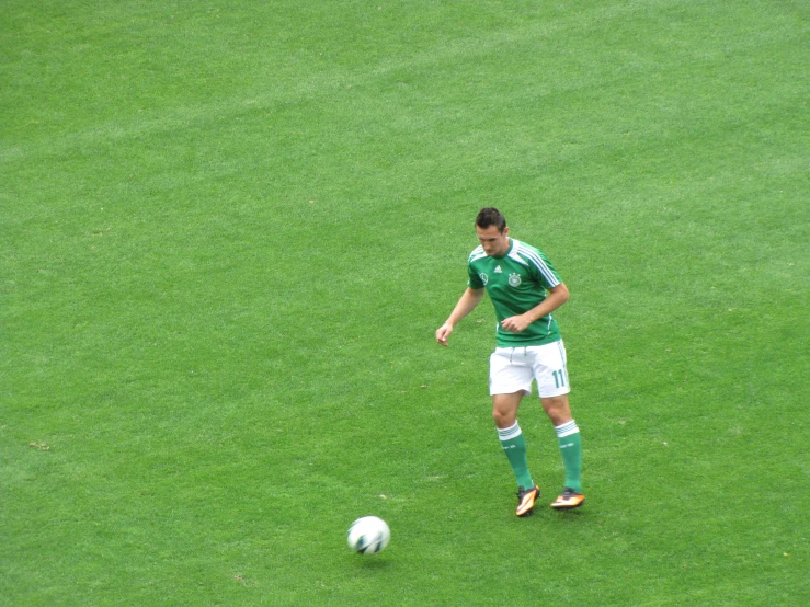 a man that is on a field with a soccer ball