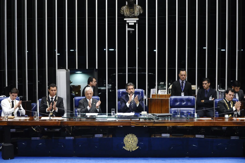 five people sitting at a conference table in front of them