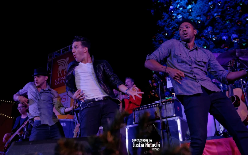 a group of young men dancing around on stage