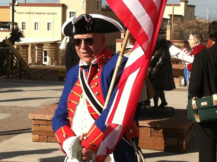 a man in a blue military uniform and hat holds a flag