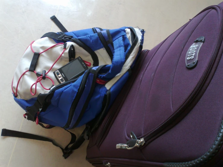 a close up of some bags on the ground with a cell phone on it