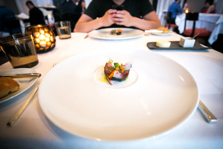 a man at a dining table with a fancy food in the middle