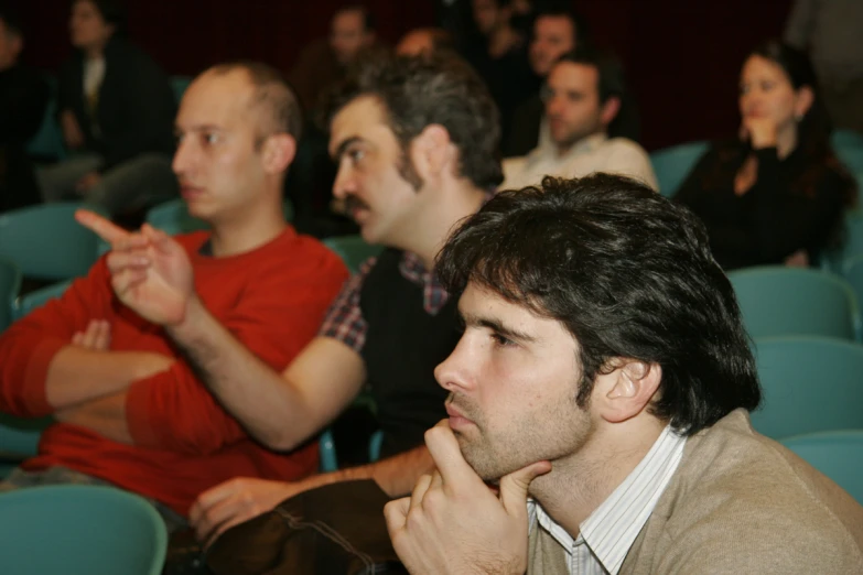 two men sitting side by side in a auditorium