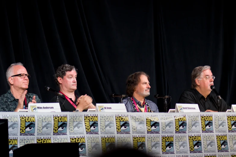 actors talking on stage during panel at convention for tv