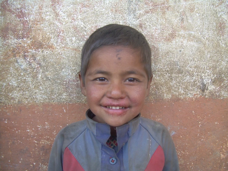 a child standing against a wall in front of a stucco background