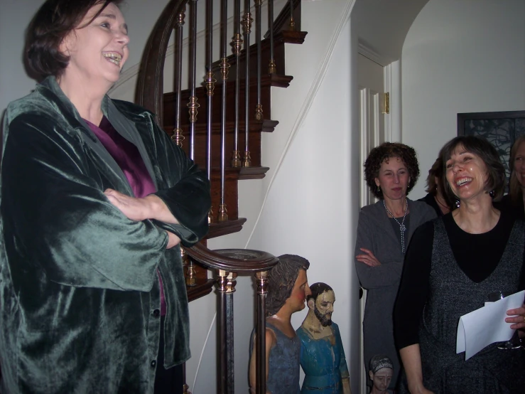 three women are laughing by a staircase