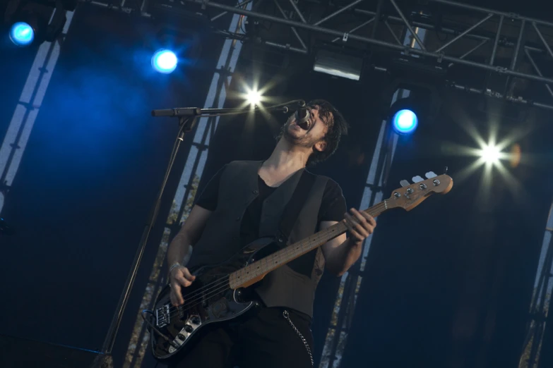 a man standing on top of a stage with a bass