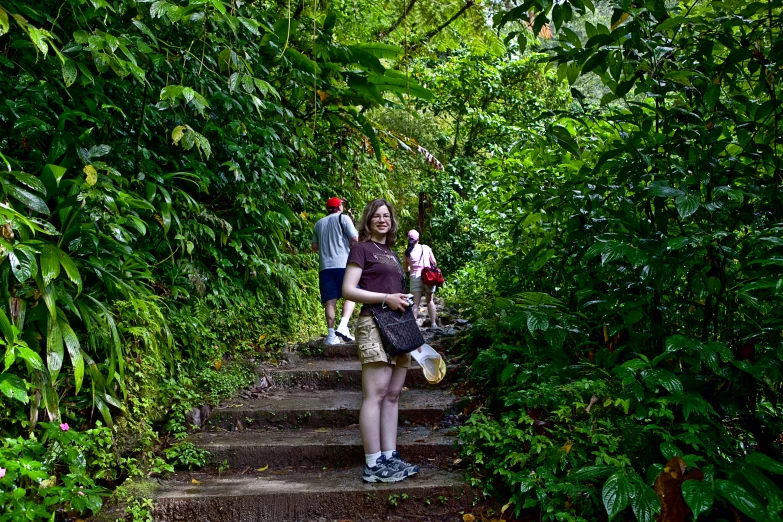 a woman carrying a teddy bear while standing on a walkway