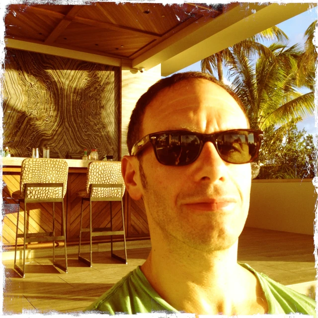 a man is sitting outside wearing sunglasses