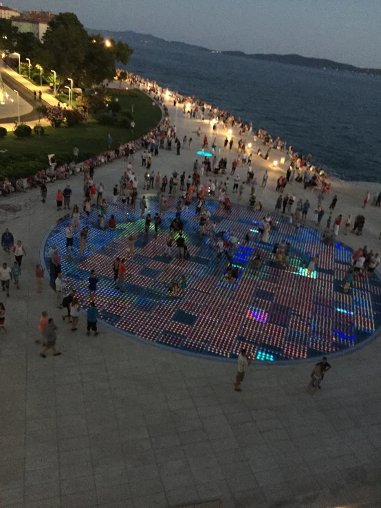 a crowd of people standing next to the ocean