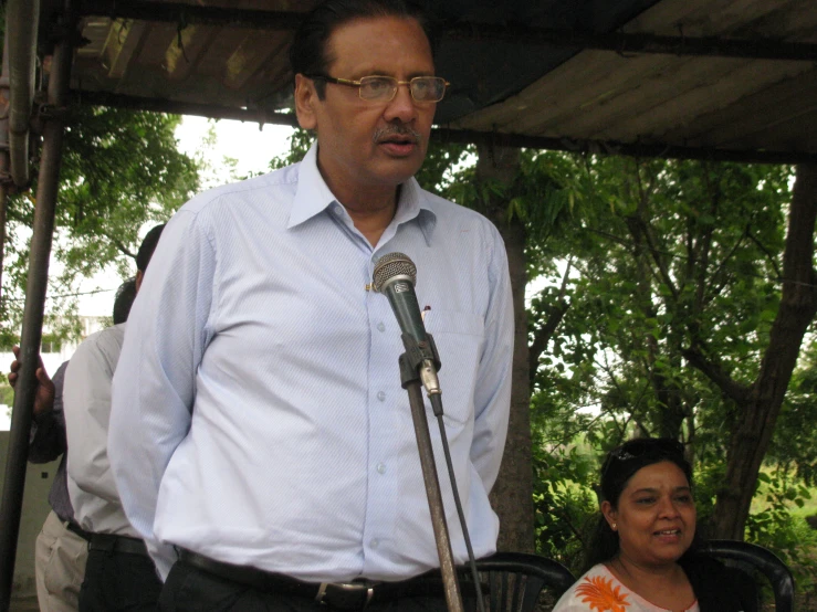 a man stands with a microphone in front of a woman