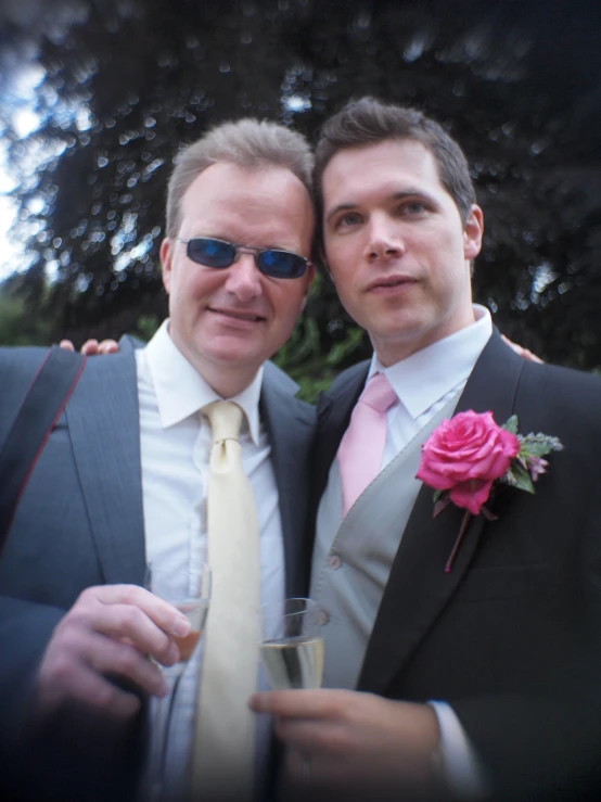 two men pose for a picture in suits