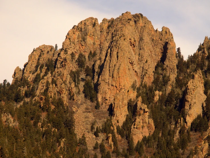 several high rocky mountains with trees growing from them