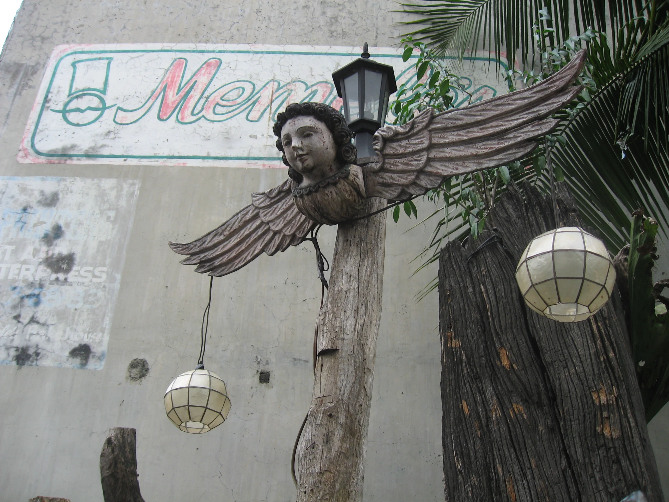 the sculpture is of an angel holding onto a lamp post