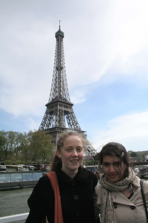 two girls standing next to each other near the eiffel tower