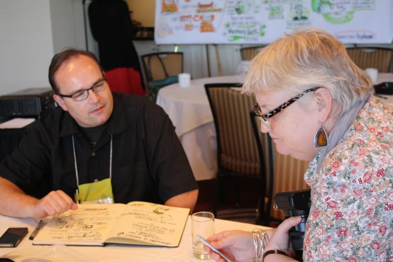 a man sitting next to a woman at a table