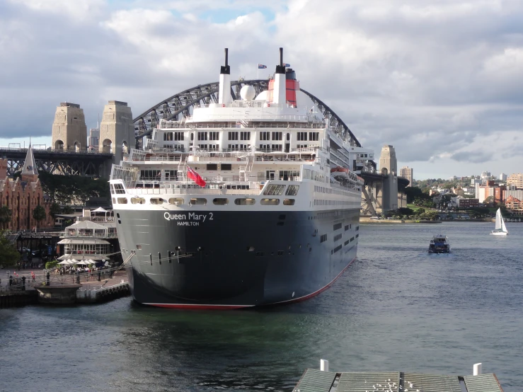 a cruise ship docked in a harbor with a bridge over it