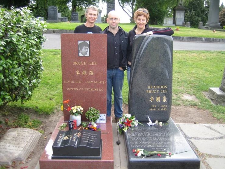 two men and a woman are standing next to a memorial