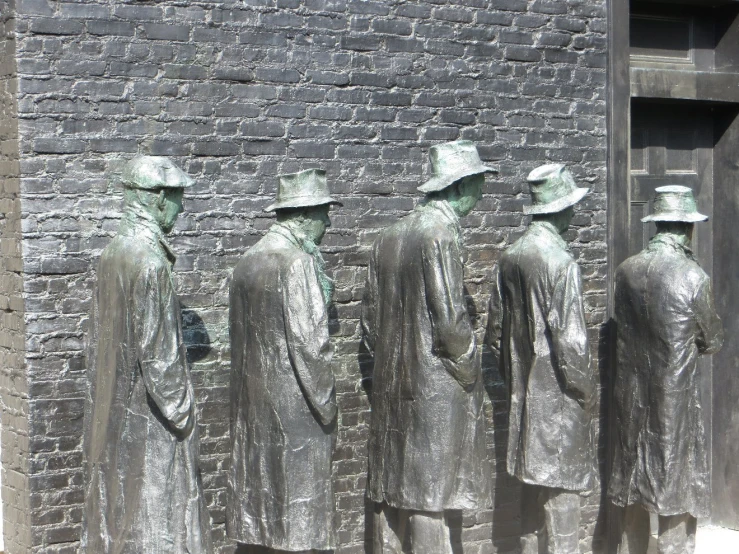 three statues, one in silver wearing white and one without