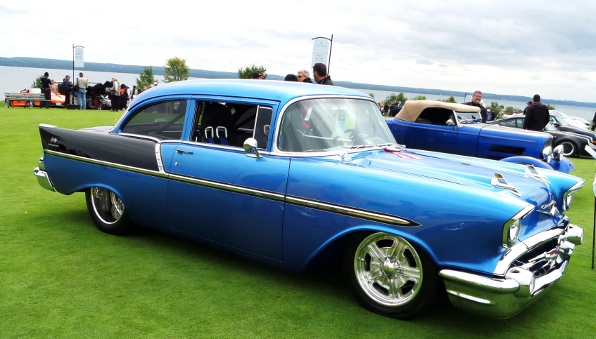 the vintage car is parked in the grass