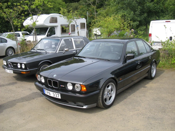 two bmw cars are parked beside one another