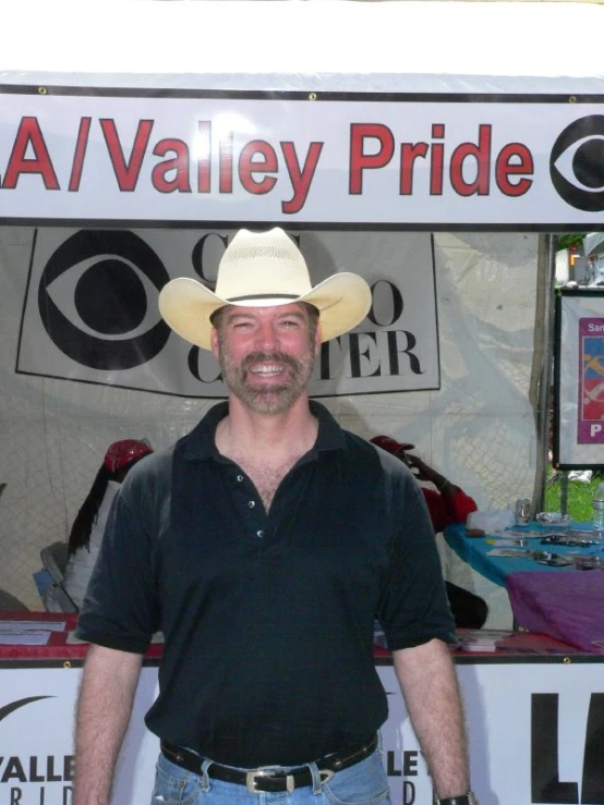 a man with his hand on his hip standing in front of a small booth