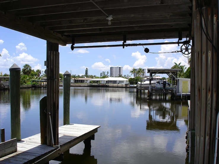 some water a dock some buildings and clouds