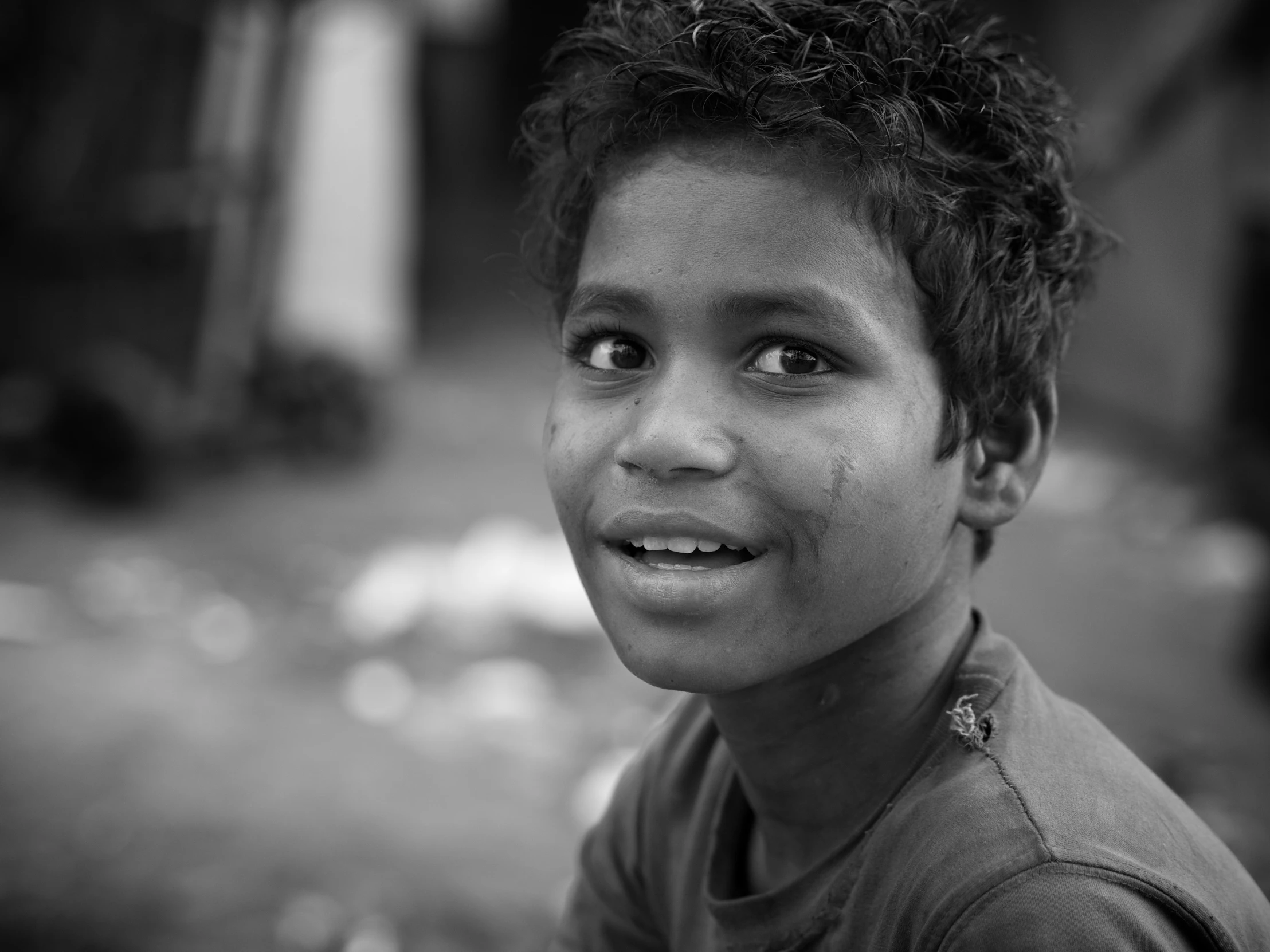 the boy is looking into the camera while he stands outside