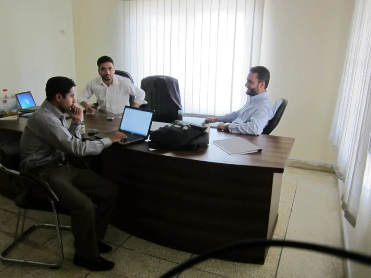 three men having a business meeting in an office