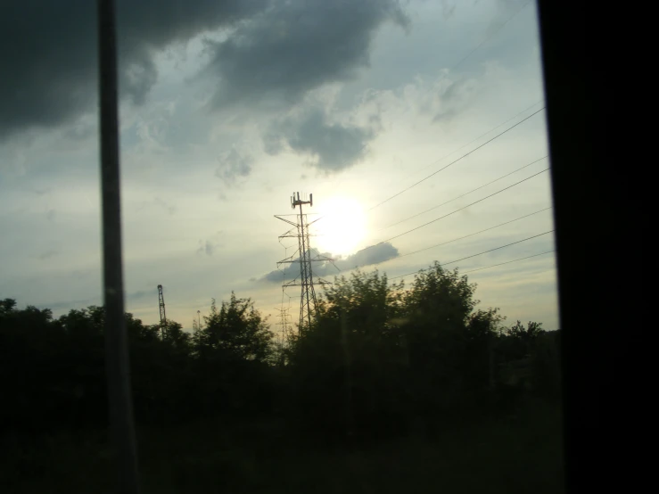 the sun peeks through dark clouds over the forest