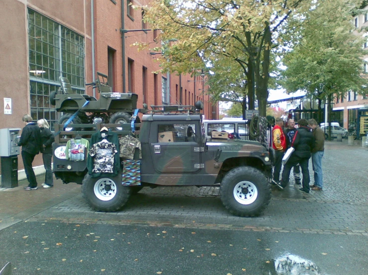 two guys are talking to some guys next to a parked truck