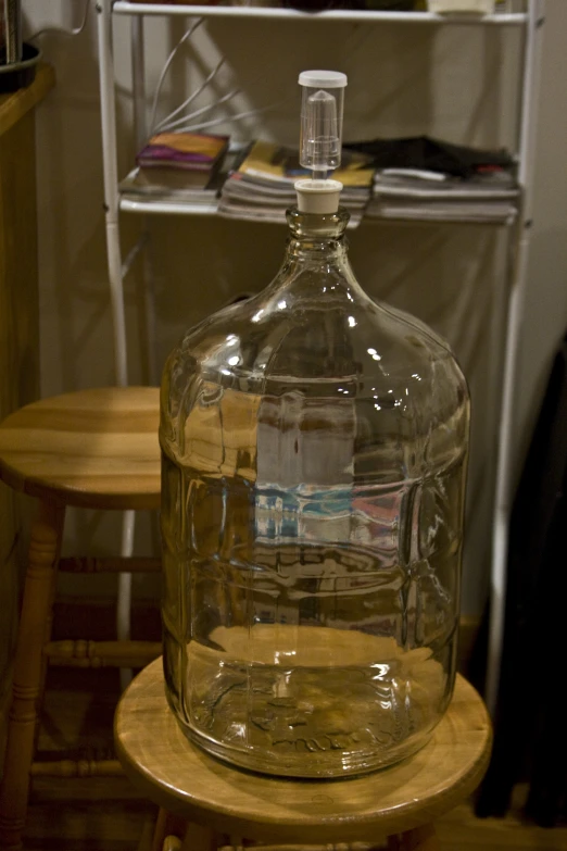 a glass water bottle sitting on top of a wooden table